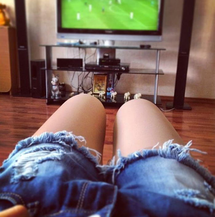 Женские ножки, смотрящие футбол